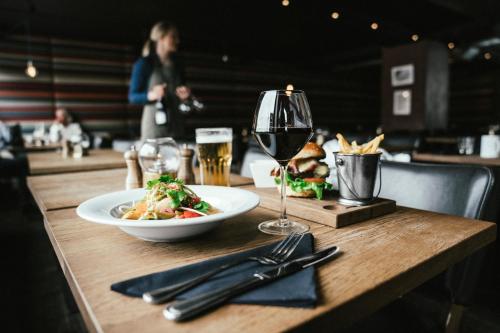 a table with a plate of food and a glass of wine at Langley Hôtel Victors in Val dʼIsère