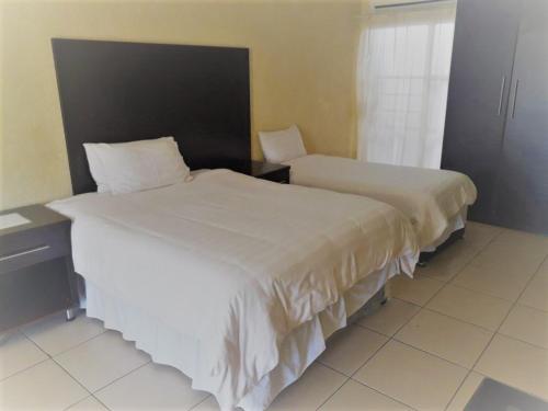 Un pat sau paturi într-o cameră la Naledzi Hotel & Conference centre