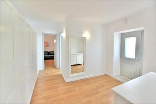 a white room with a hallway with a mirror at Villa Loukia in Hydra