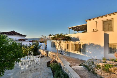 a patio with chairs and a table in a house at Villa Loukia in Hydra