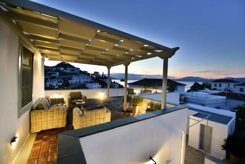 a rooftop deck with chairs and a pergola at night at Villa Loukia in Hydra