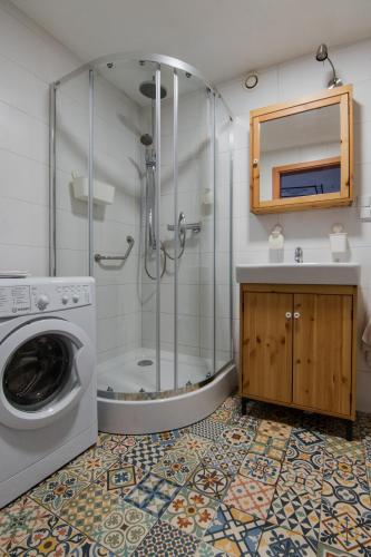 a bathroom with a shower and a washing machine at Good Times House in Katowice