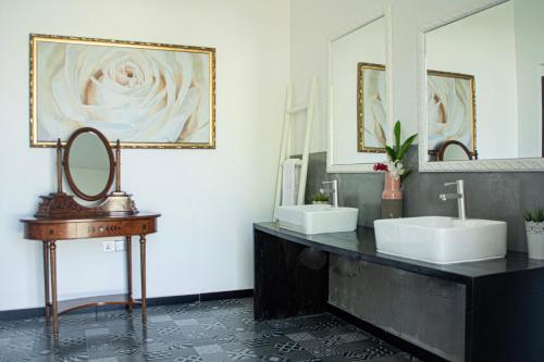 a bathroom with two sinks and two mirrors at Opera Hotel in Nungwi
