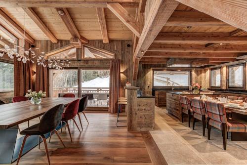 une salle à manger avec des plafonds en bois, des tables et des chaises dans l'établissement Le Hameau des Nants, à Chamonix-Mont-Blanc