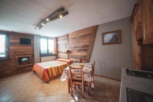 a bedroom with a bed and a table with chairs at Chalet Della Guida in Bardonecchia