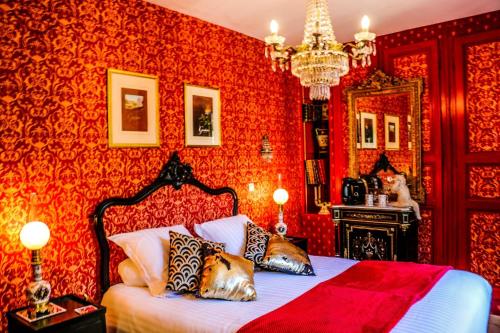 Schlafzimmer mit roten Wänden und einem Bett mit Kissen in der Unterkunft Chez fabrice in Dun-sur-Auron