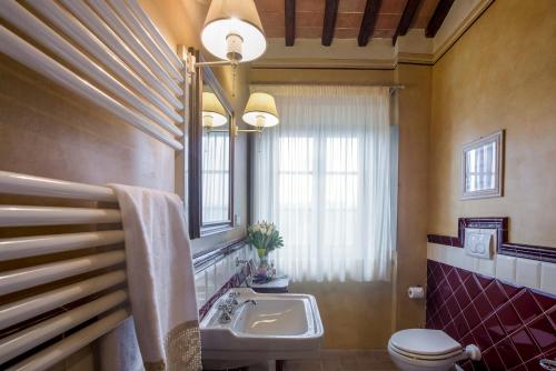 uma casa de banho com um lavatório, um WC e um espelho. em Tenuta Guardastelle - Agriturismo and vineyard em San Gimignano
