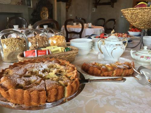 un tavolo con una torta e altri dolci sopra di Tenuta Guardastelle - Agriturismo and vineyard a San Gimignano