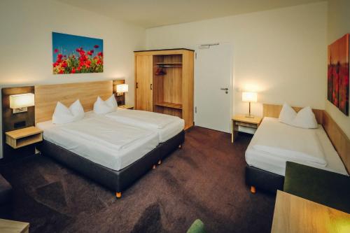 a hotel room with two beds and two lamps at Hotel Europa in Bamberg