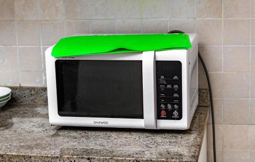 a white microwave with a green top on a counter at RÉSIDENCE DOLCE VITA - BONANJO in Douala