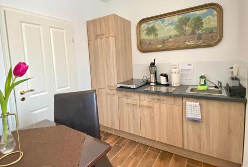 a kitchen with wooden cabinets and a table and a mirror at Guest house Villa Fritz in Potsdam