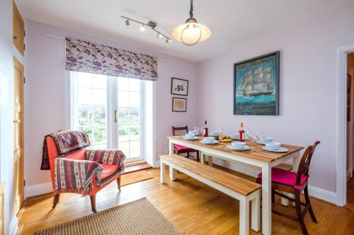 a dining room with a table and chairs and a window at Beach House - Aldeburgh Coastal Cottages in Aldeburgh