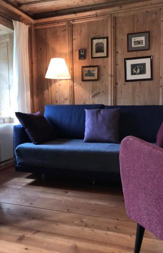 a blue couch in a room with wooden walls at Haus Buol Bergün in Bergün