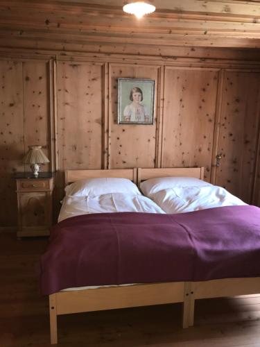 1 dormitorio con 1 cama con una foto en la pared en Haus Buol Bergün, en Bergün