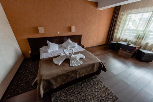 a hotel room with a bed with a bow on it at Vila Hera Luxury in Predeal