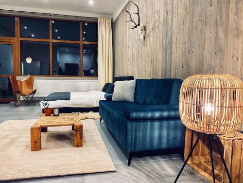 uma sala de estar com um sofá azul e uma mesa em Apartamenty Piwniczna em Piwniczna