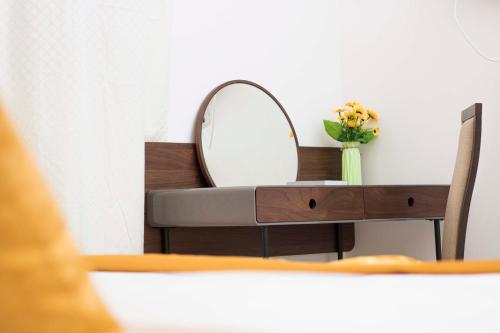 a mirror and a table with a vase of flowers at RÉSIDENCE DOLCE VITA - BONANJO in Douala
