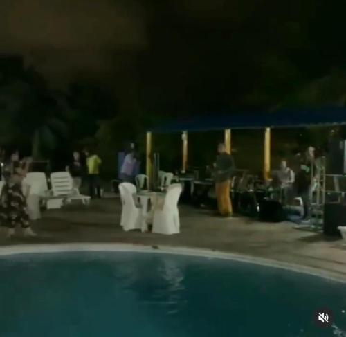 a group of people standing around a pool at night at Hotel de Trânsito da PM-PE in Olinda