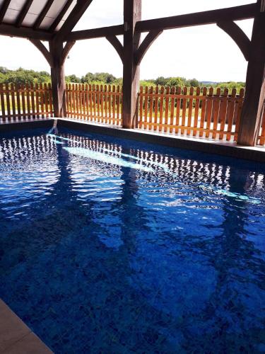 une piscine avec une clôture en bois et de l'eau bleue dans l'établissement Domaine des grandes landes, à Saint-Paul-la-Roche