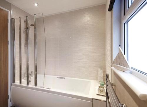 a bathroom with a shower with a glass door at Swanage Bay View Resort in Langton Matravers