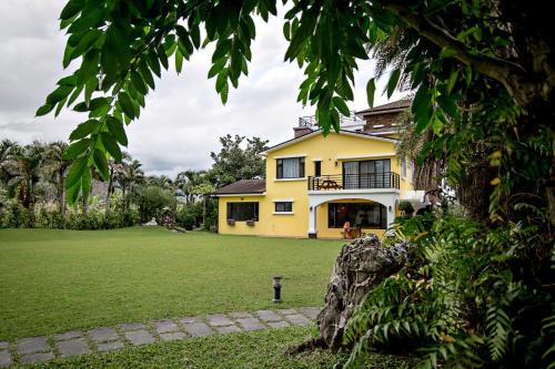 a yellow house with a large yard in front of it at Greenfield Villa in Fengping