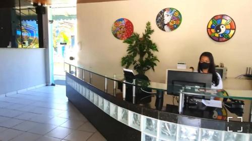 a woman standing at a counter in a restaurant at Hotel de Trânsito da PM-PE in Olinda