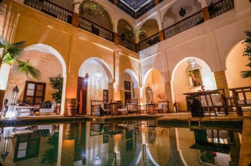 a building with a pool in the middle of it at Riad Amira in Marrakesh