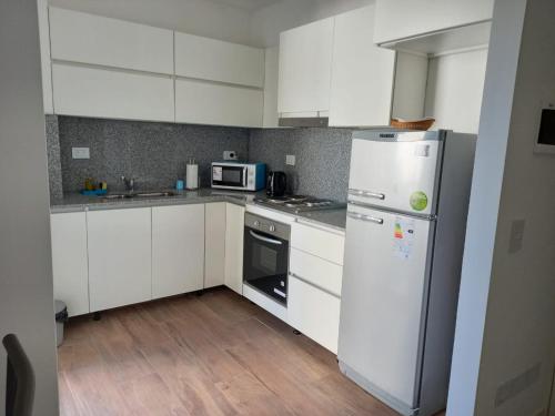 a kitchen with white cabinets and a white refrigerator at Departamento a cuadras del hospital Italiano in Buenos Aires