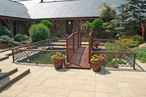 a garden with two potted plants and a wooden gate at Chale Bay Farm in Ventnor