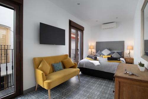 Un dormitorio con una cama y una silla amarilla. en No 17 Competa, en Cómpeta