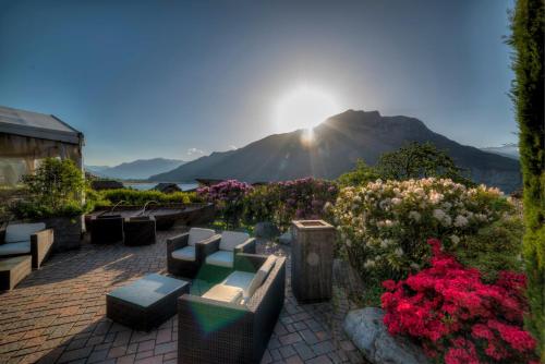a garden with flowers and a mountain in the background at Hotel Saligari in Verceia
