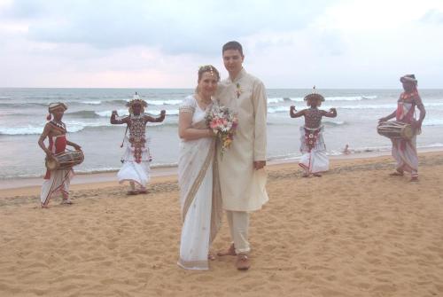 a bride and groom standing on the beach at Mermaid Hotel & Club in Kalutara
