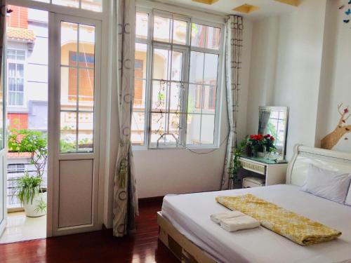 a bedroom with a bed and a large window at Primrose Homestay Cao Bang in Cao Bằng