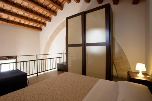 a bedroom with a bed and a glass door at Il Borgo Del Principino in Favignana