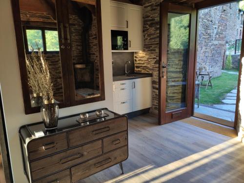 une cuisine avec une commode en bois dans une pièce dans l'établissement Casas de Outeiro, à Samos