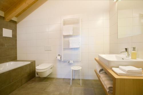 a bathroom with a sink and a toilet and a tub at Appartements Berg 170 in Damuls