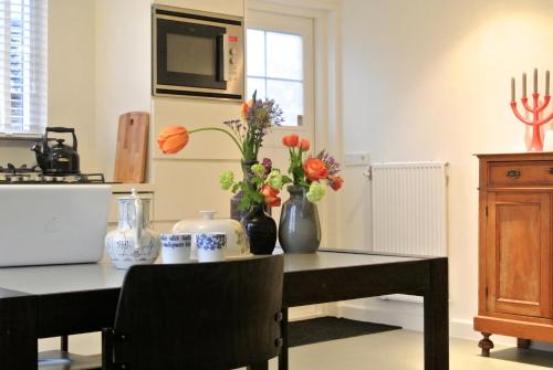 De Heerlykheid في نوينين: مطبخ مع طاولة عليها إناء من الزهور