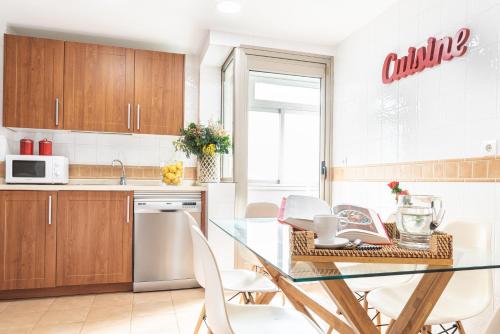a kitchen with a glass table and white chairs at Pacificio Beachfront in Málaga