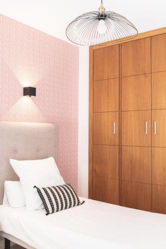a bedroom with a white bed and a brown cabinet at Pacificio Beachfront in Málaga