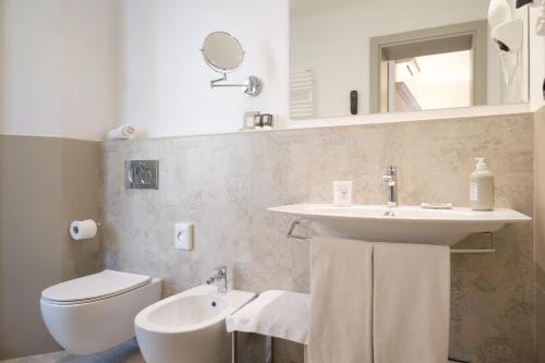 a white bathroom with a sink and a toilet at Hotel Touring in Bologna