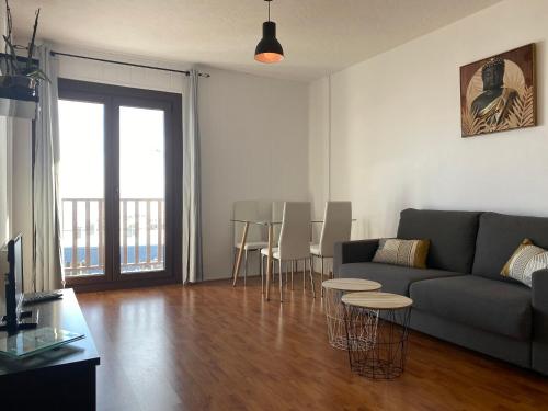 ein Wohnzimmer mit einem Sofa, einem Tisch und Stühlen in der Unterkunft Apartamentos Grifovacances Nevada in Pas de la Casa
