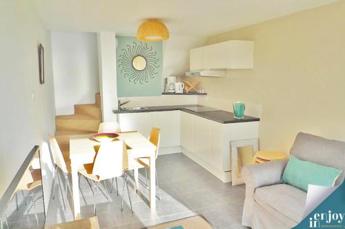 a kitchen and living room with a table and a dining room at Villa Denise Petit Gîte in Barneville-Carteret