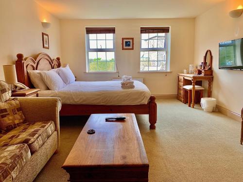 uma sala de estar com uma cama e um sofá em La Ville Hotel em Alderney