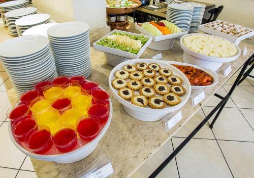 a buffet with plates and bowls of food on a counter at Estanplaza Nações Unidas in Sao Paulo