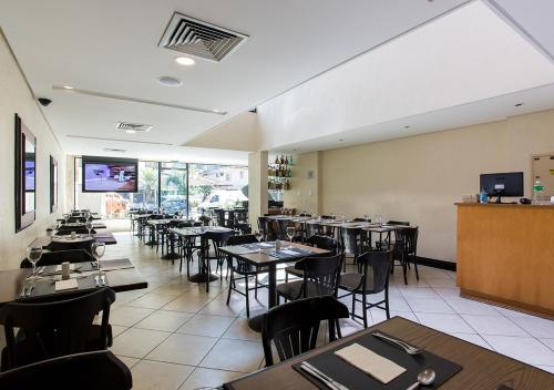 a dining room with tables and chairs in a restaurant at Estanplaza Nações Unidas in Sao Paulo