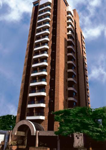a tall building with a tree in front of it at Estanplaza Nações Unidas in Sao Paulo
