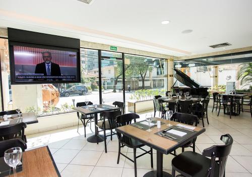 a restaurant with tables and a tv on the wall at Estanplaza Nações Unidas in Sao Paulo