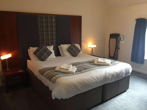 a bedroom with a large bed with two towels on it at Polochar Inn in Lochboisdale