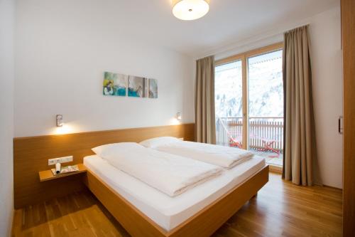 a bedroom with a bed and a large window at Appartements Berg 170 in Damuls