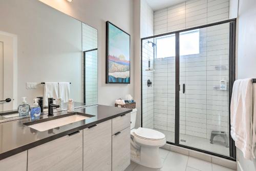 a white bathroom with a toilet and a shower at Trendy Denver Townhome - Walk to Mile High Stadium in Denver